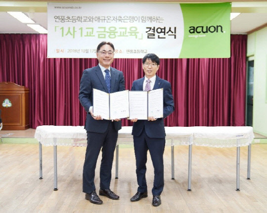 17일 경기도 파주시 연풍초등학교에서 열린 1사1교 금융교육 자매결연식에서 전명현 애큐온저축은행 대표(왼쪽)와 김우석 연풍초등학교 교장이 기념사진을 찍고 있다. 애큐온저축은행 제공
